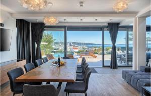 a dining room with a table and chairs and a living room at Nice Home In Kastel Gomilica With Sauna in Kaštela