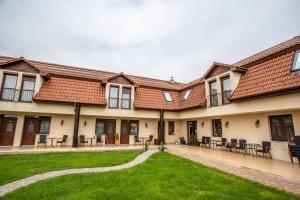 un edificio con mesas y sillas en un patio en Petrény Borpanzió, en Egerszalók