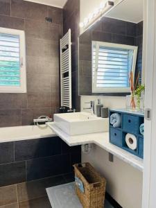 een badkamer met een wastafel, een bad en een spiegel bij MY HUMBLE HOUSE -Appartamento in villa con vista lago in Oggiono