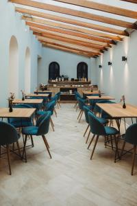 un restaurante con mesas de madera y sillas azules en Kokoa Hotel Cusco en Cusco