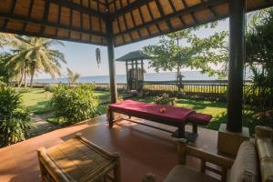 a porch with a bench and a view of the ocean at Bali North Beach Villa - Ocean Front in Tianyar