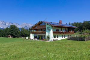 una casa en una colina con un campo verde en Gästehaus Lärcheck Berchtesgaden FeWo Morgensonne, en Berchtesgaden