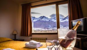 eine Flasche Champagner auf einem Tisch mit zwei Gläsern in der Unterkunft OIKOS in Ushuaia