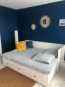 1 dormitorio con 1 cama con pared azul en Jeter l’ancre - studio, en Calais