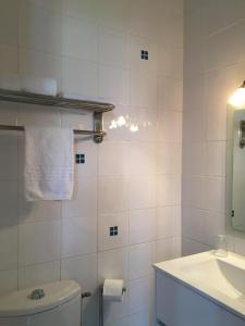 ein weißes Bad mit einem WC und einem Waschbecken in der Unterkunft Hotel Val De Saone Lyon Caluire Rillieux in Sathonay-Camp