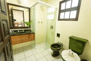 y baño con ducha, aseo y lavamanos. en Cabanas Praia Mole Florianopolis en Florianópolis