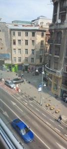 ein blaues Auto, das eine Stadtstraße mit Gebäuden entlangfährt in der Unterkunft OldTown Studio in Bukarest