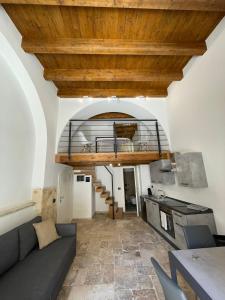 ein Wohnzimmer mit einem Sofa und einer Holzdecke in der Unterkunft GROUND STONE in Bari