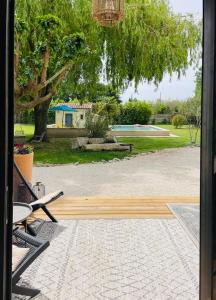 a porch with a view of a park with a bench at Mas des muses in LʼIsle-sur-la-Sorgue