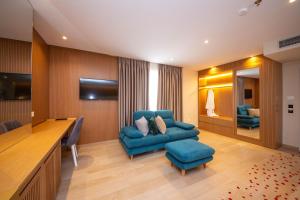 a room with a blue couch and a chair and a desk at Merar Hotel in Golem