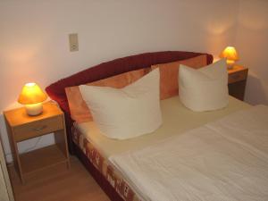 een slaapkamer met een bed met kussens en 2 lampen bij Ferienwohnung Zirkelstein in Bad Schandau