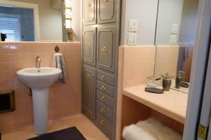 un baño con lavabo y espejo en Oakwood Manor - Steps to Oaklawn, minutes to Downtown, Lakes, More, en Hot Springs 25 fotos más