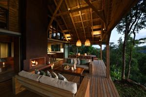 an outdoor living room of a house with a fireplace at ChamGaia off-grid eco-villa in Chamarel