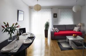 uma sala de estar com um sofá vermelho e uma mesa em Apartman Dada em Krapinske Toplice