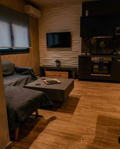 ein Wohnzimmer mit einem Sofa und einem Flachbild-TV in der Unterkunft A hidden gem in Volos *LUXURY HOME* in Volos