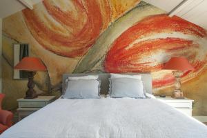 Dromen in Drempt في Drempt: غرفة نوم بسرير مع لوحة على الحائط