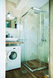 a shower in a bathroom with a washing machine at A hidden gem in Volos *LUXURY HOME* in Volos