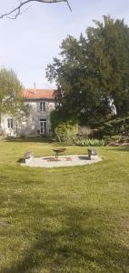 a park with a bench in the middle of a field at Maison blanche in Cherval