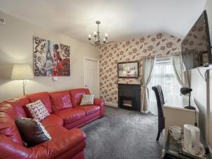 a living room with a red couch and a fireplace at McCarthy's B&B in Clonmel