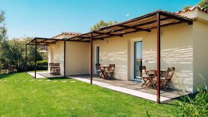 a patio with chairs and a table in a yard at B&B Sole Mare Luna in Lu Lioni