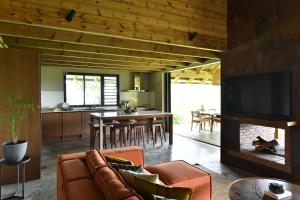 een woonkamer met een bank en een eetkamer bij ChamGaia off-grid eco-villa in Chamarel