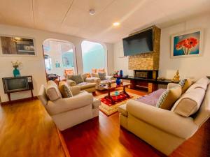 a living room with couches and a flat screen tv at Hotel Maceo Chico in Bogotá