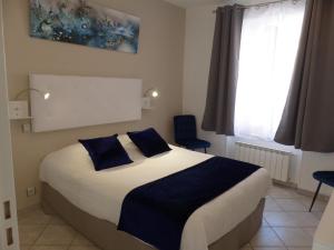 - une chambre avec un grand lit et des oreillers bleus dans l'établissement Logis Auberge de l'Isard, à Saint-Lary