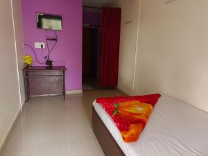 a bedroom with a bed with a red blanket on it at Voyage Munnar Laya Home Stay in Suryanelli