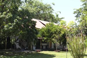 a house with trees in front of a yard at Amaya's Hostel in Jaloba