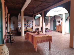 Habitación grande con una mesa en el centro en Riad Douar Des Oliviers, en El Arba