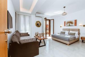 a bedroom with a bed and a couch and a chair at Deluxe Suites in Chania