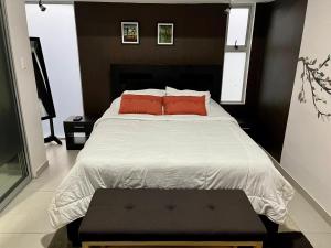 sypialnia z dużym łóżkiem z 2 czerwonymi poduszkami w obiekcie Costa Rica San Jose Full and Comfortable Apartament Pinares Curridabat w San José