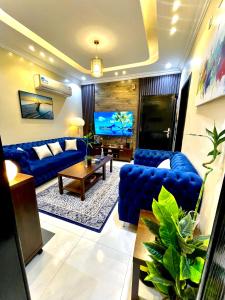 a living room with blue couches and a flat screen tv at الجوهرة الزرقاء بجوار قرية السماء - سما أبها in Abha
