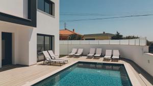 een terras met stoelen en een zwembad op een huis bij Villa Atlantica One in Lourinhã