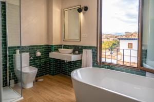 a bathroom with a tub and a sink and a window at Florentia San Nicolás in Granada