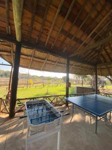 una mesa de ping pong bajo un pabellón con un campo en Confratelli Cabañas en Paso de la Patria