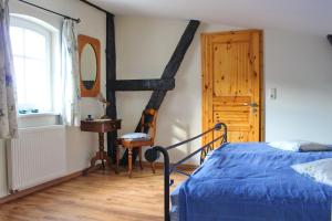 a bedroom with a blue bed and a wooden floor at Zur Alten Tabakscheune in Buchholz