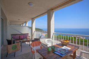 a balcony with a table and chairs and the ocean at Casa l'Alivi in Luri