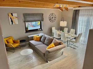 a living room with a couch and a dining room at Nowe Apartamenty Puck in Puck