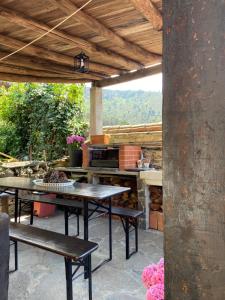 a patio with a table and benches and a grill at Casa da Carolina in Lousã