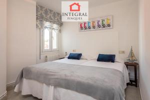 a white bedroom with two beds with blue pillows at Atlantis Palamós Home in Palamós