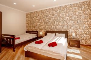 two beds in a bedroom with red pillows on them at Apartments Rynok Square 12 in Lviv