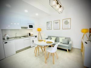 uma cozinha e sala de estar com uma mesa e um sofá em Apartamentos Guaditania em Mérida