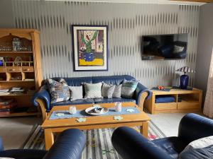 a living room with a blue couch and a coffee table at Ferienwohnung Zur Heide in Rheine