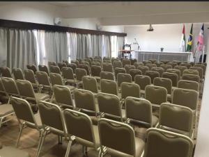 ein leerer Hörsaal mit Stühlen und Vorhängen in der Unterkunft Hotel Espadarte in Iriri + 80 Fotos