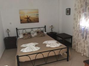 1 dormitorio con 1 cama con toallas en Aegeon Pension, en Egíali