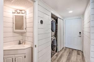 a bathroom with a sink and a washer and dryer at Chic Fort Walton Condo about 2 Blocks to Beach! in Fort Walton Beach +27 photos
