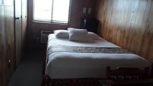 a small room with two beds and a window at The Orca Inn in Friday Harbor