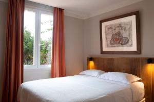 a bedroom with a large bed and a window at Hôtel Le Porquerollais in Porquerolles