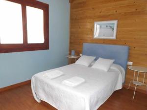 um quarto com uma cama grande e 2 almofadas brancas em EL VENERO DE MOSTOLES em Constantina
